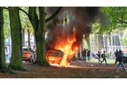 Uitgebrande politiewagen blijft achter na rellen en persfotograaf gewond naar ziekenhuis in Den Haag